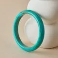 Close-up of Bohemian acrylic bangle with turquoise marble pattern on white ceramic support - Lake Green Marble Style (AB0093-7)