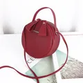 Chic red circular crossbody bag with double zippers and gold lettering logo detail - Burgundy