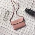 Pink pebbled leather mini crossbody bag with gold snap button on a checkered background - Pink