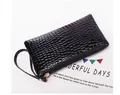 Detail of black crocodile embossed clutch bag with metal zipper and wristlet strap - Black