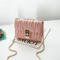 Pink quilted crossbody bag featuring a golden chain strap and stylish twist lock - Pink