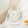 White crocodile pattern crossbody bucket bag with golden hardware and top handle - White