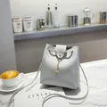 Light gray bucket bag in matte leather featuring a gold deer charm and drawstring detail - Light Gray