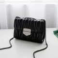 Elegant black matelassé shoulder bag with dark metal chain strap and geometric lock - Black (Gunmetal Hardware)