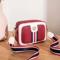 Red and white crossbody camera bag with V logo and striped fabric shoulder strap - Burgundy
