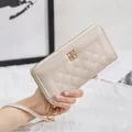 Elegante beige gesteppte lange Brieftasche mit Goldlogo und abnehmbarer Handschlaufe - Weiß