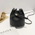 Minimalistische zwarte bucket bag van generfd leer met witte stiksels en gouden gesp - Zwart