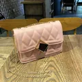 Pink quilted crossbody bag with gold chain strap and square buckle on wooden table - Pink