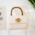 Mini cream faux crocodile leather handbag with bamboo handle and gold chain strap - White