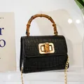 Mini black crocodile embossed handbag featuring a vintage bamboo handle and chain strap - Black