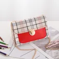 Bolso bandolera de mujer a cuadros con cuero rojo y cadena dorada en escena lifestyle - Rojo
