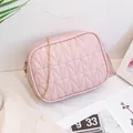 Pink quilted crossbody bag with gold chain strap and tassel detail on white background - Pink