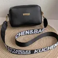 Bolso bandolera cuadrado negro con placa dorada y correa ancha de tejido suave - Negro