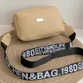 Bolso bandolera beige estilo cámara con correa ancha de tela y detalles en dorado - Caqui