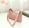 Detalle del bolso de hombro rosa con textura de cuadros, hebilla dorada y cierre imán - Rosa