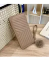 Detailed shot of long taupe V-quilted wallet with wristlet strap and fluffy fur ball charm - R007 Khaki