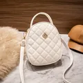 Elegant white quilted crossbody bag with golden flower clasp on marble surface - White