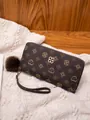 Long brown zip-around wallet with golden pattern and soft pompom charm accessory - Coffee