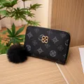 Portafoglio nero vintage con chiusura a quadrifoglio dorata e ciondolo a pompon - Nero