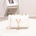 Quilted white crossbody bag with gold V logo and metal chain tassel detail - White