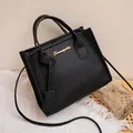 Elegante borsa tote nera in pelle martellata con logo dorato e tracolla sottile - Nero