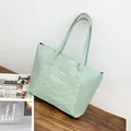 Mint green quilted tote bag with golden floral charm and elegant metal hardware detail - Light Green