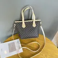 Bolso tote marrón tejido con asas blancas y patrones geométricos en una mesa de madera - Marrón