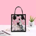 Transparent PVC daisy handbag with black trim, gold chain strap, and interior cosmetics - Black