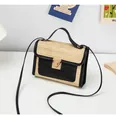 Detalle del bolso bandolera de paja tejida y cuero negro con cierre de corazón dorado - Negro