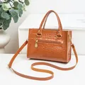 Braune Handtasche aus Kunstleder mit Krokoprägung und goldenem Reißverschluss - Braun