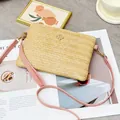 Sac bandoulière en paille tressée avec bandoulière rose et détail de fleur dorée - Rose
