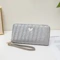 Cartera larga gris plata con textura tejida, dije de mariposa blanca y correa - Gris