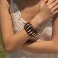Close-up of bohemian amber resin and gold metal segmented stretch bracelet on wrist - Gold Amber Straight Stripe Style (AB0036-6)