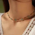 Detail van boheemse gouden ketting met blauwe ovale stenen op modelhals met wit kant - Helder Blauwe Ovaal Edelsteen (KN0583-3)