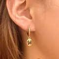 Golden hoop earring featuring a hanging letter M pendant for a personalized look - Letter M Disc Style (KE1774)