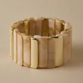 Elastische blokarmband van beige marmerhars en gepolijste goudkleurige metaalsegmenten - Beige Geel Marmer En Goud