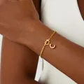 Close-up of golden chain bracelet with knot design and pavé zircon letter C pendant - Letter C / Gold
