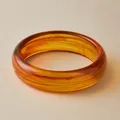 Exaggerated amber acrylic wide bangle featuring unique marbled resin swirl patterns - Amber Quicksand (AB0043-1)