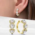 Détail de boucles d'oreilles dorées en forme de poire avec zircons sur le mannequin - Or+Blanc