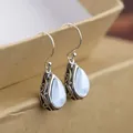 Vintage silver drop earrings with light blue waterdrop gemstones and intricate scrollwork - White