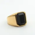 Macro-opname van een vintage heren zegelring met goudkleurige band en zwarte edelsteen - Goud Zwart