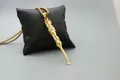 Close-up of golden dragon embossed pendant necklace with unique functional ear pick tool - Fashion Gold