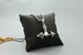 Macro detail of polished barbell pendant necklace on a jewelry display pillow - Silver