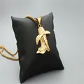 Golden necklace featuring a western cowboy hat and boot pendant on a black pillow - Fashion Gold