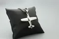Colgante de avión pulido con cadena de metal sobre fondo de cuero negro elegante - Cadena de Cuentas / Plata de Moda