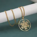 Collier avec pendentif cube de Métatron doré disposé sur un support cylindrique blanc - Or