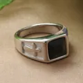 Macro shot of men's vintage steel ring with black onyx and embossed cross detail - US 7 / Silver Black Stone