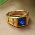 Detailed shot of golden cross ring with a square blue gemstone on textured fabric - Gold Blue Stone