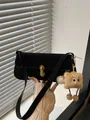 Schwarze mattierte Baguette-Tasche mit Goldschloss und braunem Plüschanhänger am Gurt - Schwarz Mit Anhänger