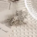 Squisita spilla a forma di leone d'argento in posa ruggente su sfondo bianco lavorato - Argento